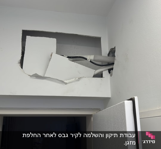 חור בקיר עם צינורות חשופים